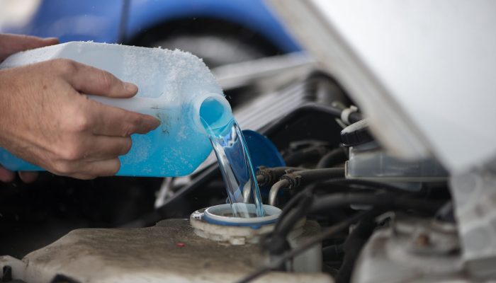 close-up-driver-pouring-blue-non-freezing-windshie-2023-11-27-05-30-08-utc-min